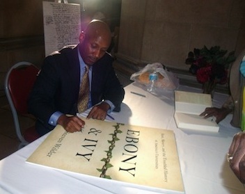 Craig Wilder signing a poster for Ebony & Ivy